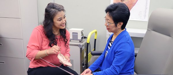 Dr. Kawi with a patient in her lab