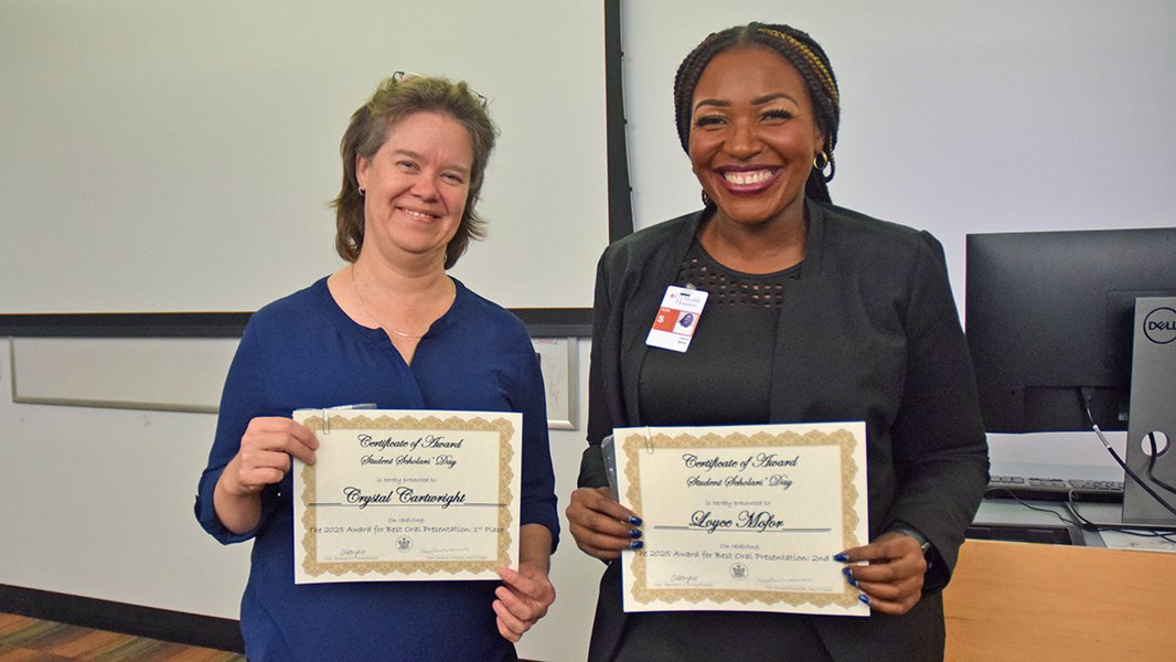 Two students holding awards