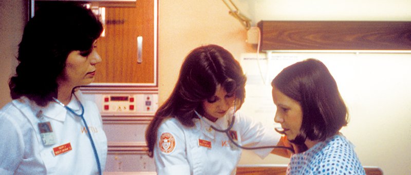 Nursing students examine a patient in the 1990s.