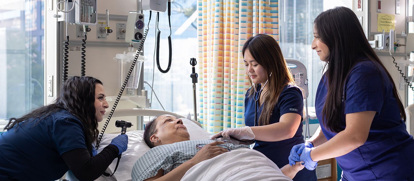 3 nursing students with a standardized patient in the sim lab