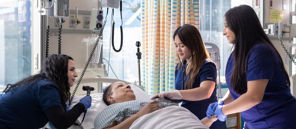 3 nursing students with a standardized patient in the sim lab