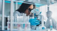 Nurse scientist looking into a microscope