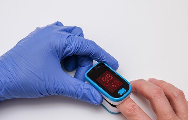 Health care worker testing someone's blood oxygenation with a pulse oximeter. Courtesy Getty Images.