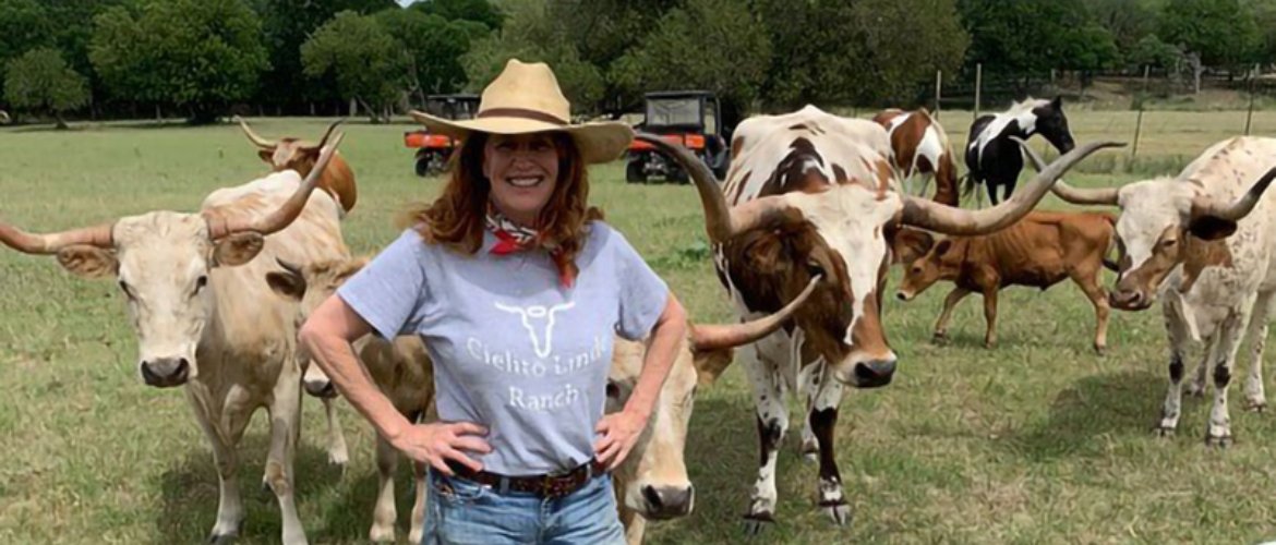 Alumna Debbie Adams on her ranch with longhorn cattle