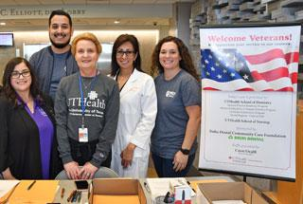 VBSN Director Bridgette Pullis and UTHealth School of Dentistry Director of Community Outreach Margo Melchor (in lab coat) stand ready at the reception desk to greet vets arriving for “Give Veterans a Smile” Day. (Photo by Dwight C. Andrews/UTHealth)