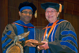 SBMI Alumnus (2015), Alumni Association member and assistant professor Deevakar Rogith, MBBS, PhD, presents the award to Dr. Johnson, May 9. (Photo by Dwight Andrews) SBMI Alumnus (2015), Alumni Association member and assistant professor Deevakar Rogith, MBBS, PhD, presents the award to Dr. Johnson, May 9. (Photo by Dwight Andrews)