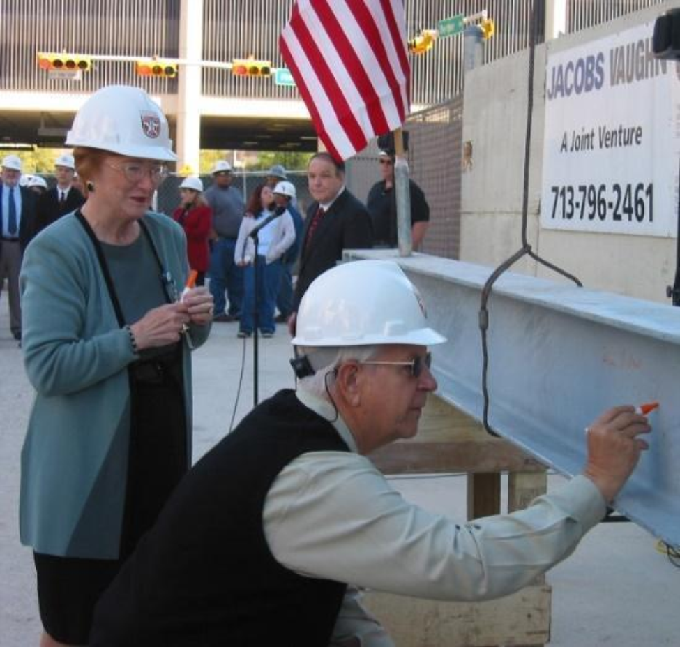 Patricia L. Stark and Robert Cizik sign a beam during construction of what would become the home of Cizik School of Nursing.